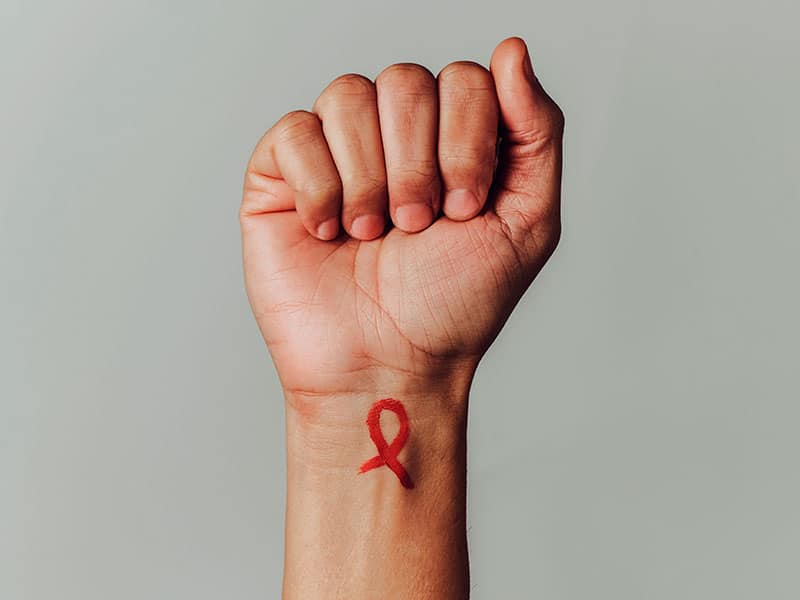 red ribbon for the fight against HIV in his wrist