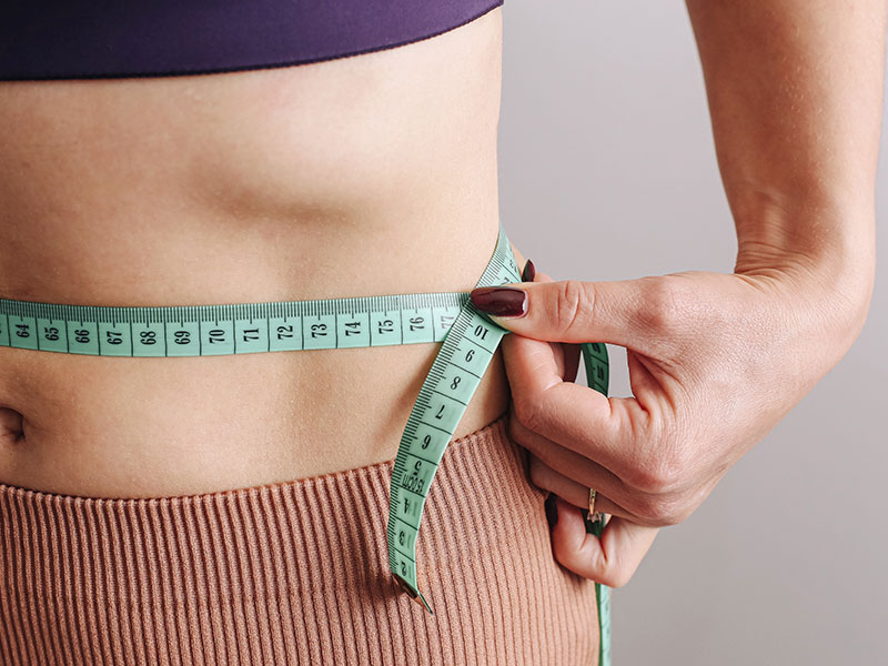 a girl measures her waist