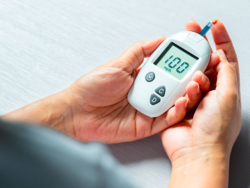 Woman's hands checking diabetes and hyperglycemia with digital blood sugar meter.