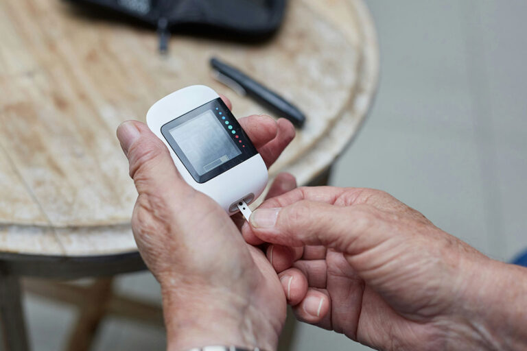 a blood glucose meter in human hands