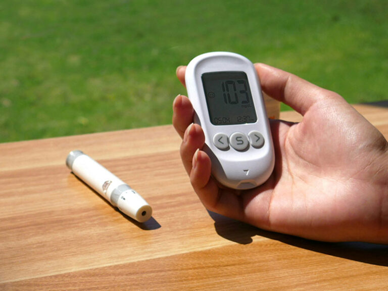 A man holds a glucose meter in his hand