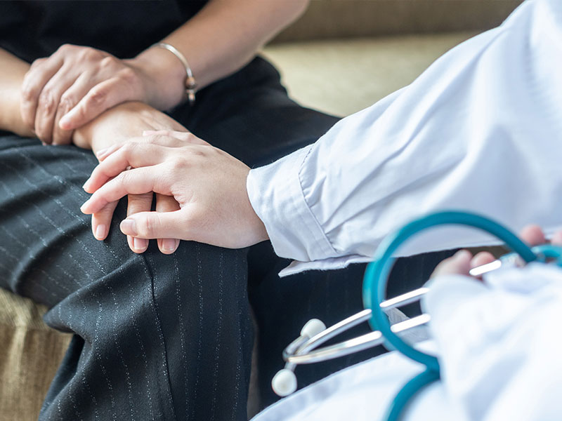 The doctor holds the patient's hand