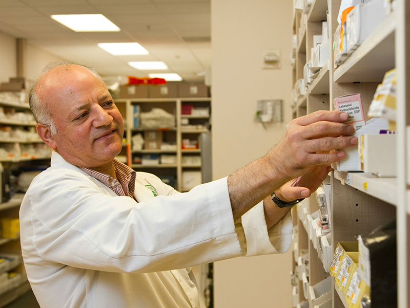 the pharmacist at the pharmacy looks at the counter and compares the drugs
