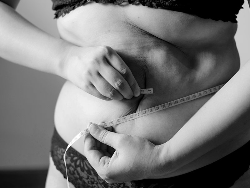 A woman measures her waist