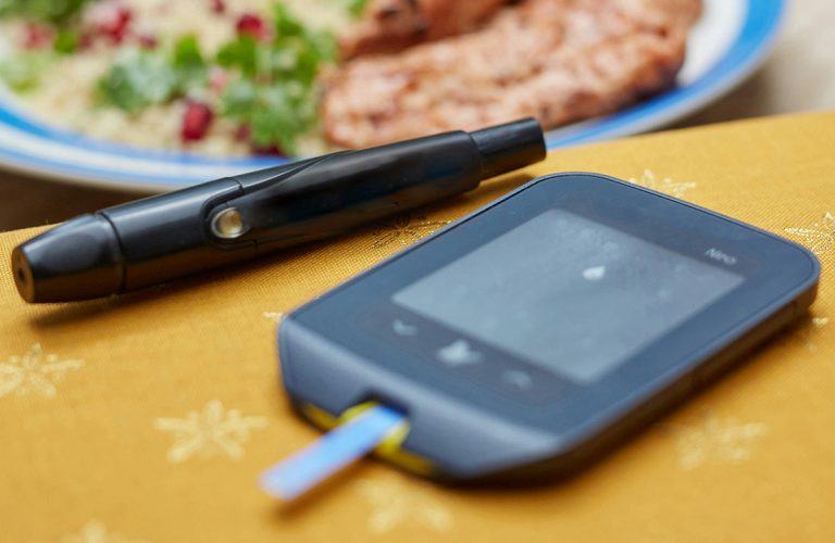 devices and medicines for the treatment of diabetes and blood sugar measurement and the food is on a plate on the table