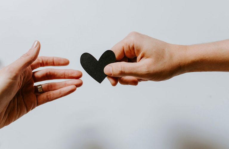 The hands reach out to each other with the heart