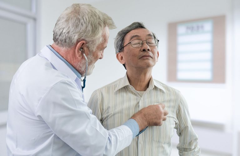 Senior doctor used stethoscope place on chest to listen the heart beating of the elderly male patient in examination room of hospital, clipping path